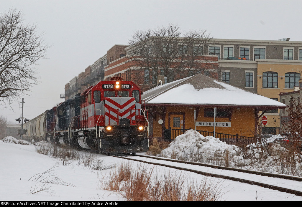 WAMX 4178 past the depot with an eastbound grain+sand train